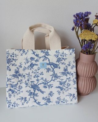 Malá taška do ruky, do které uložíš všechny potřebné věci nebo malý nákup. Krásný vzor modrých větviček a ptáků rozzáří i...